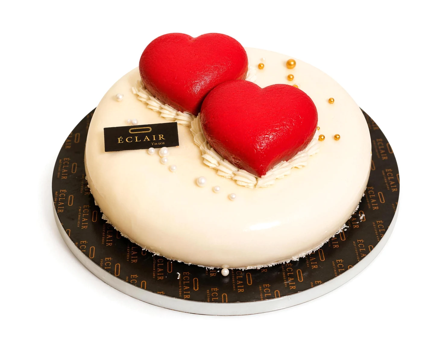 Entremets ivoire au glaçage miroir, deux cœurs rouges et perles dorées — ÉCLAIR Pâtisserie, Casablanca